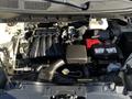 The image shows the engine compartment of a 2017 Nissan NV200 featuring an inline-four engine with various components like the intake manifold battery and hoses