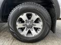 A close-up of a 2014 Ford F-150 wheel featuring a silver alloy rim with five spokes and a Goodyear WinterCommand tire