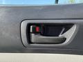 Close-up of the door handle of a 2015 Toyota Tacoma featuring a black plastic design with a red release button