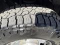 Close-up of a rugged tire tread from a 2013 Ford F-250 SD showing deep grooves and a durable design suitable for off-road conditions