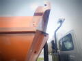A 2016 International WorkStar 7500 with an orange dump body and a flatbed truck section visible in the foreground