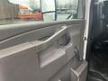 The interior door panel of a 2018 Chevrolet Express featuring a handle and controls for windows and door locks