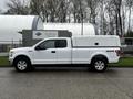 A white 2017 Ford F-150 pickup truck with a closed canopy in the truck bed and 4x4 branding on the side. The truck has alloy wheels and a crew cab design.