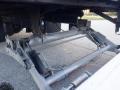 Close-up of the suspension system of a 2014 International Durastar showing the metallic components and hydraulic cylinders
