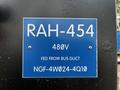 A blue informational sign attached to a black unit displaying specifications including RAH-454 480V and NGF-4W024-4Q10