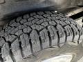 A close-up view of a rugged tire from a 2004 Ford Econoline showing deep tread patterns designed for traction and durability