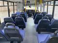 Interior of a 2017 Chevrolet Express showing rows of blue upholstered seats with a driver's area visible at the front