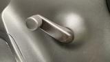 A close-up of the door handle crank of a 2021 International CV515 in a solid dark color with a textured finish