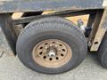 Close-up of a rusty tire mounted on a wheel with visible lug nuts on a JLG Industries 1014 lift