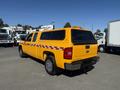 A yellow 2013 Chevrolet Silverado 1500 pickup truck with a checkerboard pattern on the side and a cap over the bed