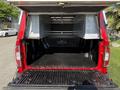 The image shows the open bed of a red 2018 GMC Canyon with a metal storage compartment above and a black bed liner