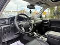 Interior of a 2021 Toyota 4Runner featuring a black steering wheel console and gear shift with leather seats