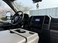 The interior of a 2020 Ford F-550 featuring a steering wheel dashboard and console with various controls and display screens
