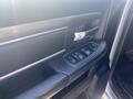 Close-up of the driver door panel of a 2021 RAM 1500 featuring the door handle and window control buttons