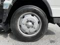A close-up view of a silver wheel from a 2015 Mitsubishi Fuso FE with black tire tread and a metal rim