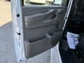 The open door of a 2014 Chevrolet Express van showing the interior panel with a handle and storage compartment