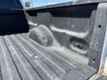 The bed of a 2014 Ford F-150 with a textured surface and a slight indentation on one side