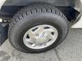 A close-up of a tire and wheel from a 2009 Ford Econoline showcasing a silver alloy rim and a black tire with a tread pattern