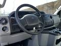 Interior of a 2019 Ford Econoline showing the steering wheel dashboard and center console with various controls and cup holders