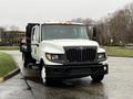 A 2012 International TerraStar truck in white with a flatbed and distinctive front grille featuring a large logo and multiple headlights