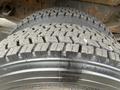 Close-up of a set of tires from a 2008 Mitsubishi Fuso FE180 showcasing deep tread patterns and wear marks on the rubber surface