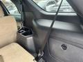 Interior view of a 2016 Ford Explorer showing a beige fabric seat and a black plastic console with cup holders and a seatbelt extending across the frame