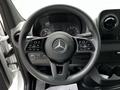 Steering wheel of a 2023 Mercedes-Benz Sprinter featuring the brand logo controls and buttons for various functions