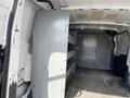 Interior view of a 2019 Ford Transit van showing a gray shelving unit installed on one side and a spacious cargo area with a flat floor and metal walls