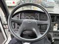 The interior of a 2005 Freightliner M2 106 featuring a black steering wheel and dashboard with various gauges and controls