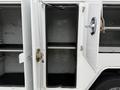 A 2020 Ford F-550 vehicle with an open compartment door revealing empty shelving inside