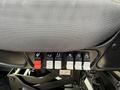 A row of switches and controls mounted on the side of a seat in a 2011 International 4300 vehicle