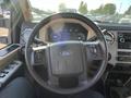 Interior view of a 2014 Ford F-350 SD with a black steering wheel featuring control buttons and a dashboard displaying gauges and a central infotainment system