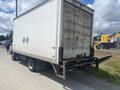 A 2012 Hino XJC720 truck with a white cargo box and visible diamond shapes on the side parked on a street