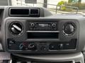 Dashboard of a 2021 Ford E-450 featuring a radio display climate control knobs and various buttons for vehicle functions