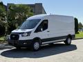 A white 2022 Ford Transit van with a high roof and large cargo area featuring a black front grille and wheel covers