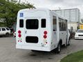 A white 2013 Chevrolet Express with a wheelchair access symbol on the back featuring large windows and red tail lights