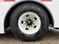 The wheel and tire of a 2011 Ford F-650 showing a white rim with green accents and a large black tire with the Hankook logo