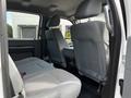 Interior of a 2016 Ford F-550 showing the backseat area with gray cloth seating and a compact center console