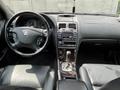 Interior view of a 2002 Nissan Maxima showing the steering wheel dashboard and center console with air conditioning controls and gear shifter