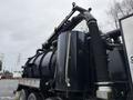2018 Kenworth T800 with a large black tank and various hoses and pipes attached to the top and sides of the vehicle