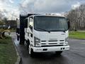 A 2015 Isuzu NPR HD truck with a white exterior and a black cargo box attached in the back