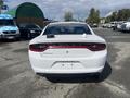 A white 2017 Dodge Charger viewed from the rear with a clean design and the Dodge logo prominently displayed on the trunklid
