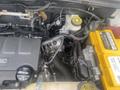 Close-up view of the engine compartment of a 2018 Buick Encore showing various components including wires battery and fluid reservoirs