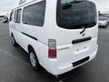 A white 2002 Nissan Van with a flat rear design displaying the word CARAVAN on the back door and round tail lights