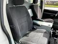 Interior view of a 2011 Dodge Grand Caravan showing two front seats with gray fabric upholstery and an armrest between them