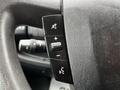 Steering wheel control panel of a 2021 RAM Promaster featuring buttons for volume adjustment and voice command