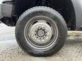 Close-up of a wheel from a 2016 Ford F-550 Super Duty featuring a metal rim and a large tire with visible tread pattern and valve stem