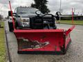 A black 2012 Ford F-550 truck equipped with a large red snow plow attached to the front