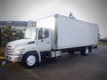 A 2013 Hino 308 truck with a white box cargo area and front cab painted in white with a black and silver grille