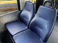 Two blue fabric-covered seats in a vehicle, featuring a textured pattern and a curved backrest design